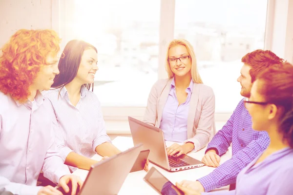 Equipo sonriente con computadoras portátiles y de mesa PC — Foto de Stock