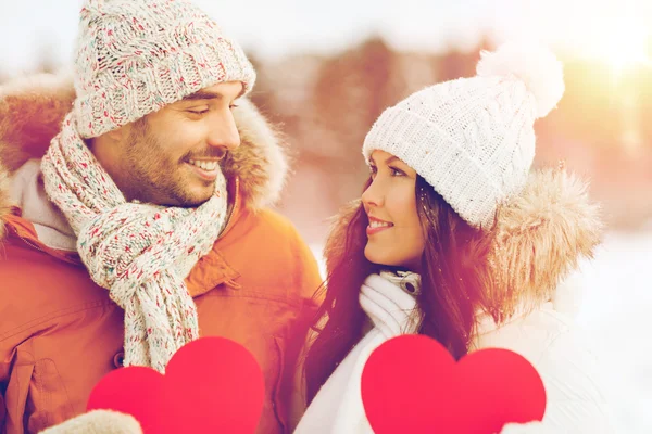 Gelukkige paar met rode harten over winterlandschap — Stockfoto