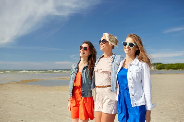 Groupe de femmes souriantes en lunettes de soleil sur la plage — Photo