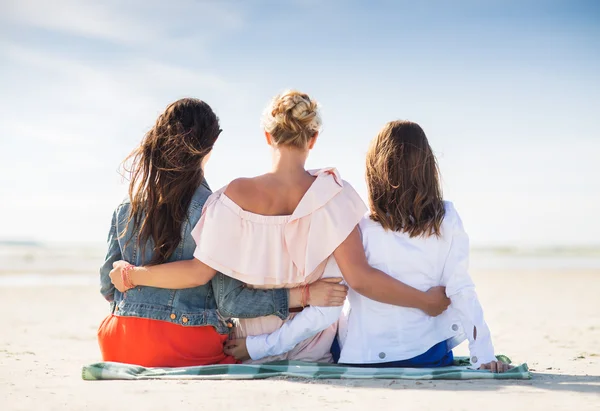 Grupo de mujeres jóvenes abrazándose en la playa — Foto de Stock