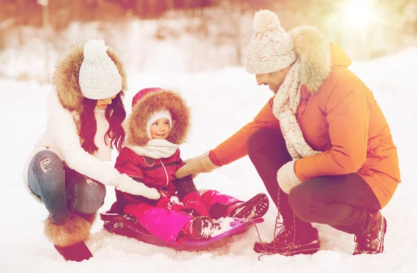 Família feliz com trenó andando na floresta de inverno — Fotografia de Stock
