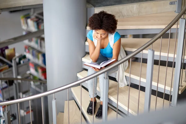 Estudiante africana leyendo libro en la biblioteca — Foto de Stock
