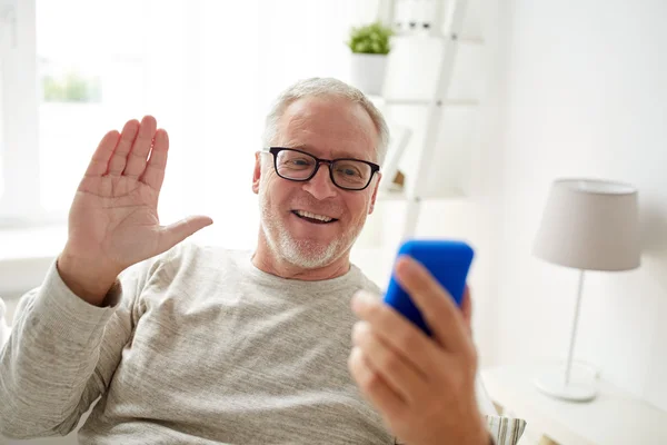 Homem sênior ter chamada de vídeo no smartphone em casa — Fotografia de Stock