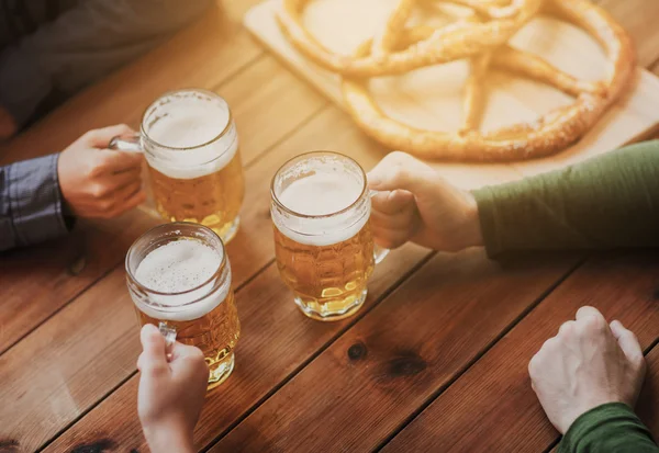 Fermer les mains avec des tasses à bière au bar ou au pub — Photo