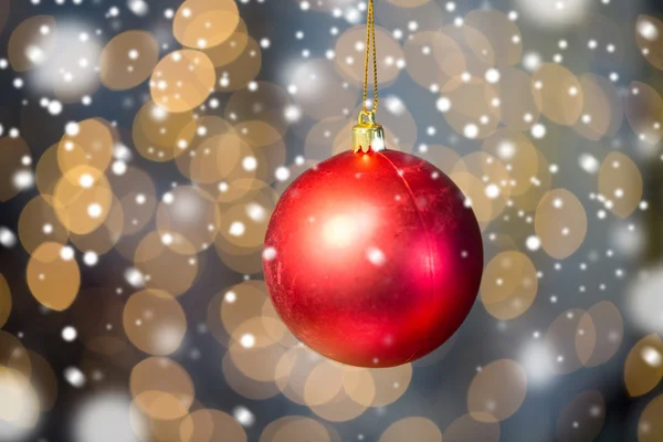 Zbliżenie na czerwoną piłkę Bożego Narodzenia nad złote światło — Zdjęcie stockowe