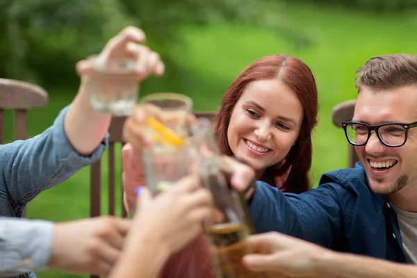 Amigos felizes batendo copos no jardim de verão — Fotografia de Stock