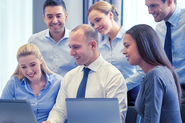 Lächelnde Geschäftsleute mit Laptop — Stockfoto