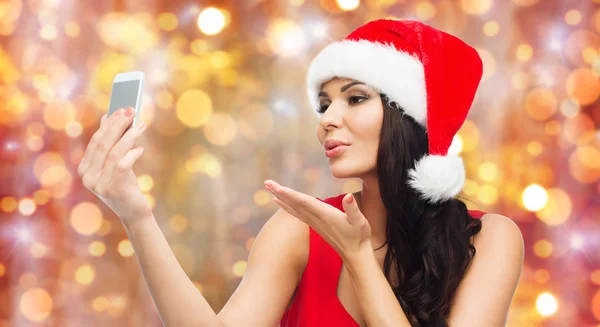 Woman in santa hat taking selfie by smartphone — Stock Photo, Image