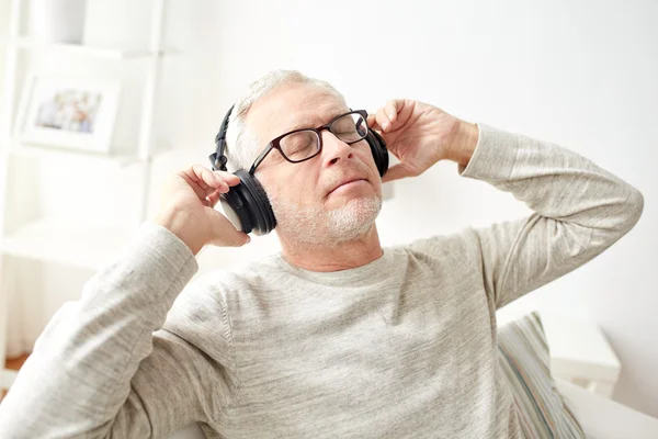 Lycklig man i hörlurar lyssna på musik i hemmet — Stockfoto