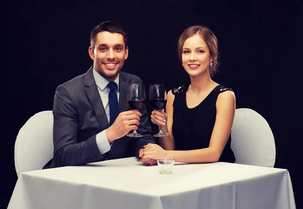 Young couple with glasses of wine at restaurant — Stock Photo, Image