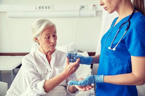 Νοσοκόμος που χορηγεί φάρμακα σε ηλικιωμένη γυναίκα στο νοσοκομείο — Φωτογραφία Αρχείου
