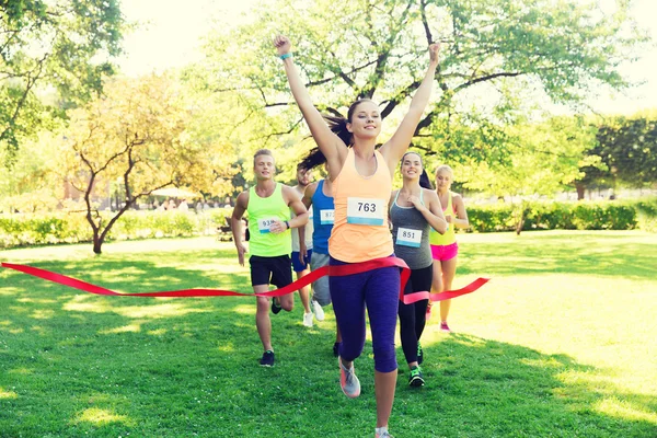 Gelukkig jonge vrouwelijke atleet winnen op race afwerking — Stockfoto