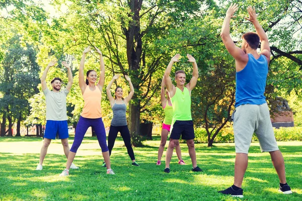 Group of friends or sportsmen exercising outdoors — Stock Photo, Image