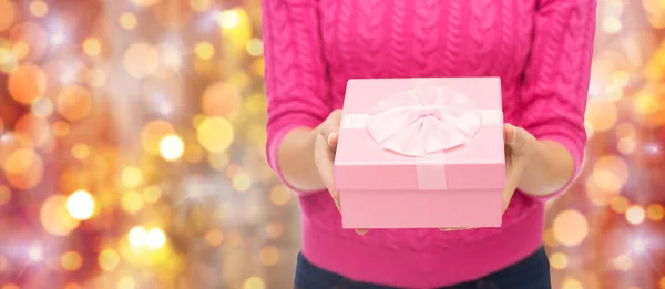 Primo piano della donna in maglione rosa contenente confezione regalo — Foto Stock