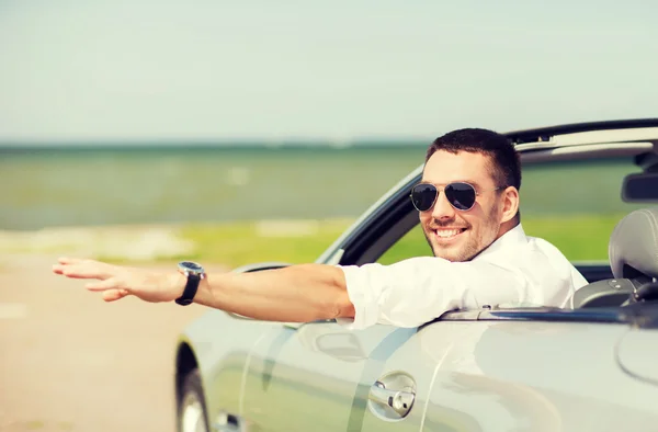Щасливий чоловік за кермом кабріолетного автомобіля і махаючи рукою — стокове фото