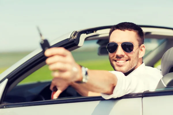 Щасливий чоловік в кабріолеті показує ключ автомобіля — стокове фото