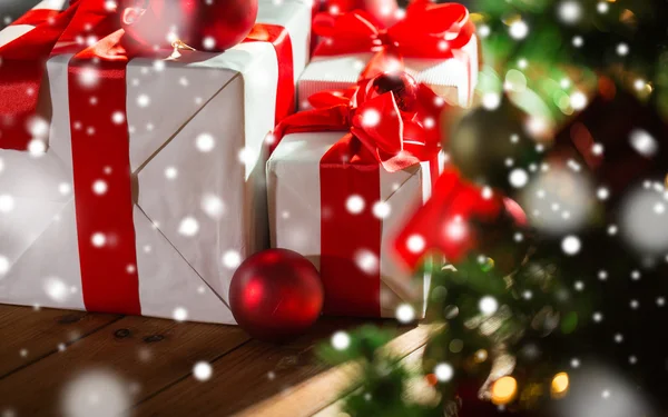 礼品盒和红球在圣诞树下 — 图库照片