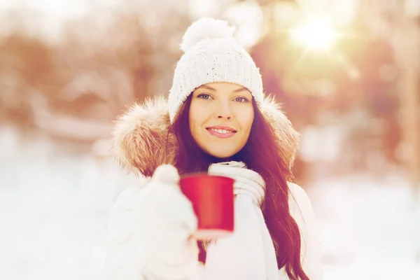 Heureuse jeune femme avec tasse de thé en plein air en hiver — Photo