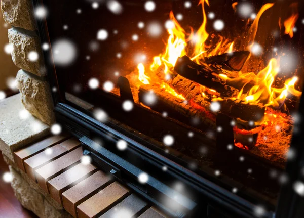 Close up of burning fireplace with snow — Stock Photo, Image