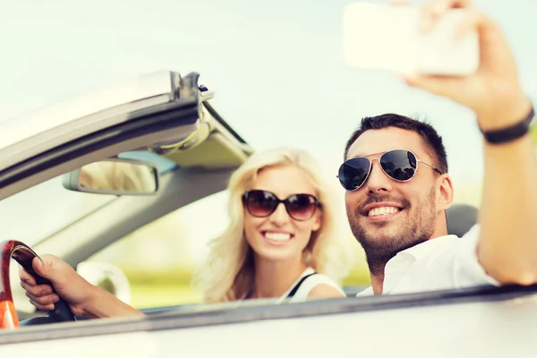 Lyckliga par i bil tar selfie med smartphone — Stockfoto