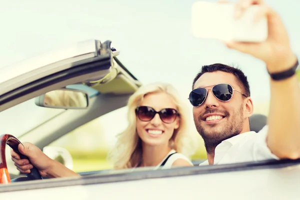 Feliz pareja en coche tomando selfie con smartphone — Foto de Stock