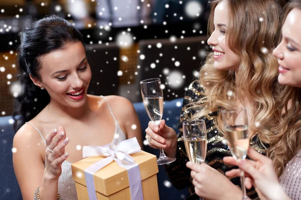 Mujeres felices con champán y regalo en el club nocturno —  Fotos de Stock