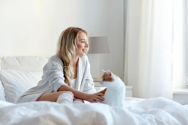 Jovem feliz com gato na cama em casa — Fotografia de Stock