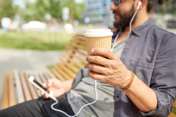 Hombre con auriculares y teléfono inteligente beber café —  Fotos de Stock