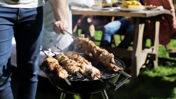 Uomo che cucina carne alla griglia alla festa estiva — Video Stock