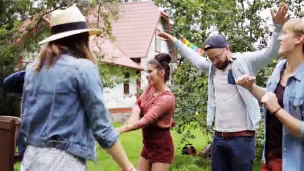 Щасливі друзі танцюють на літній вечірці в саду — стокове відео