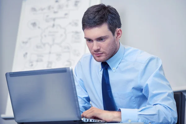 Empresário sentado com laptop no escritório — Fotografia de Stock