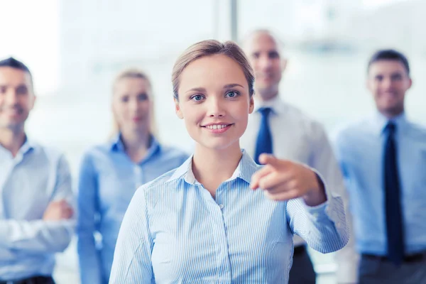 Smiling businesswoman pointing finger on you — Stock Photo, Image