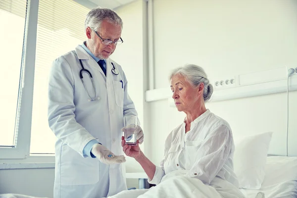 Médico dando remédio para a mulher idosa no hospital — Fotografia de Stock