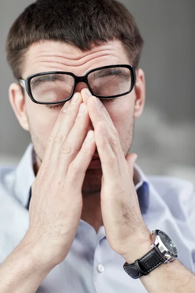 Empresário cansado com óculos no escritório — Fotografia de Stock