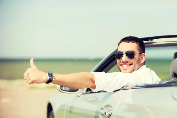 Homem feliz dirigindo carro e mostrando polegares para cima — Fotografia de Stock