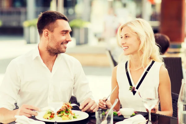 Happy couple eating dinner at restaurant terrace — Stock Photo, Image