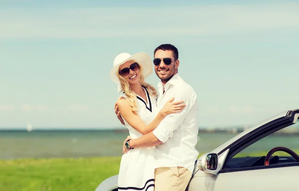 Glücklicher Mann und Frau umarmen sich in der Nähe von Auto auf See — Stockfoto