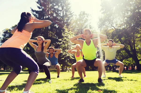 Group of friends or sportsmen exercising outdoors — Stock Photo, Image