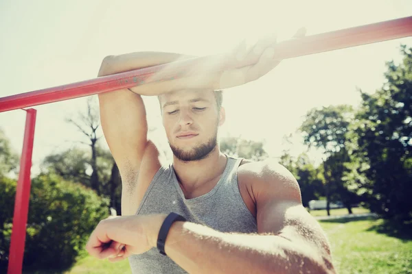 Man with heart-rate watch exercising outdoors — Stock Photo, Image