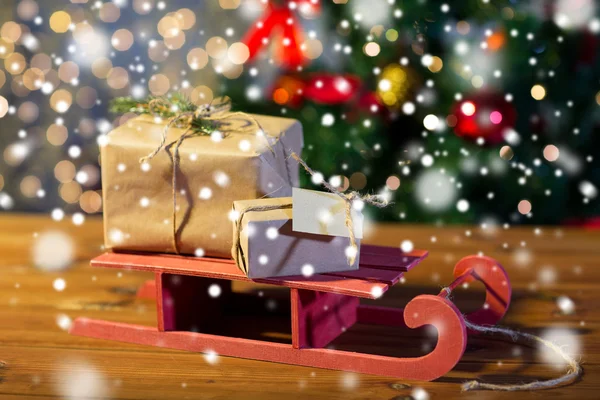 Nahaufnahme von Weihnachtsgeschenkboxen auf Holzschlitten — Stockfoto