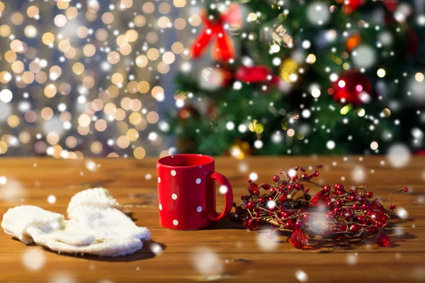 Чашка чая с варежками и рождественские украшения — стоковое фото