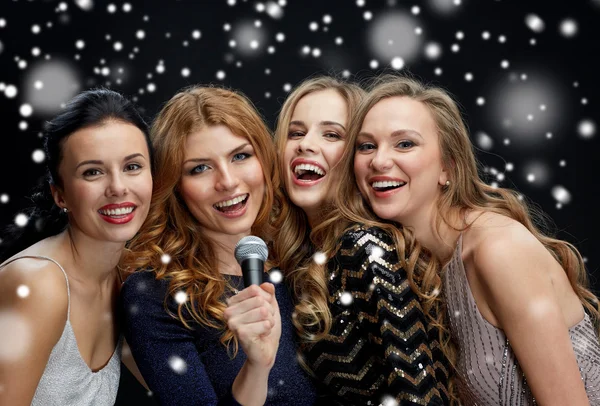 Felici giovani donne con microfono cantare karaoke — Foto Stock