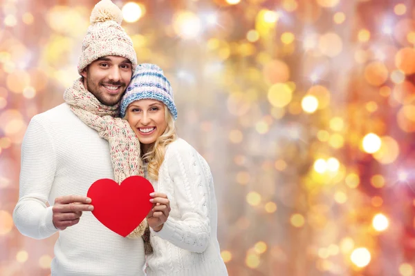 Pareja sonriente en ropa de invierno con corazones rojos —  Fotos de Stock