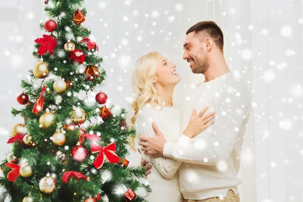 Feliz pareja abrazándose cerca de árbol de Navidad en casa — Foto de Stock