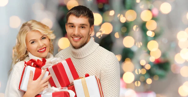 Ευτυχισμένο ζευγάρι στο πουλόβερ κρατώντας τα δώρα Χριστουγέννων — Φωτογραφία Αρχείου