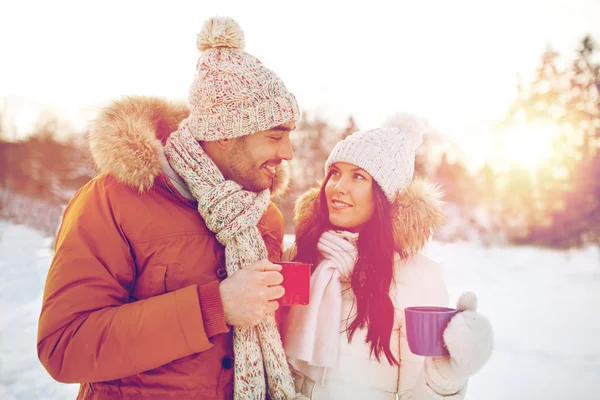 Щаслива пара з чашками чаю над зимовим пейзажем — стокове фото
