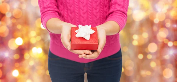 Närbild på kvinna i rosa tröja håller presentförpackning — Stockfoto