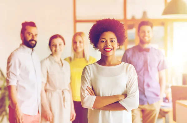 Feliz joven mujer sobre creativo equipo en la oficina — Foto de Stock