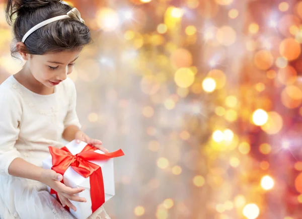 Улыбающаяся маленькая девочка с подарочной коробкой — стоковое фото