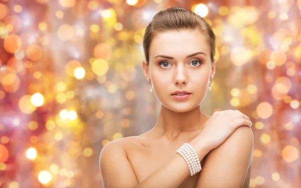 Vacker kvinna med pärla örhängen och armband — Stockfoto